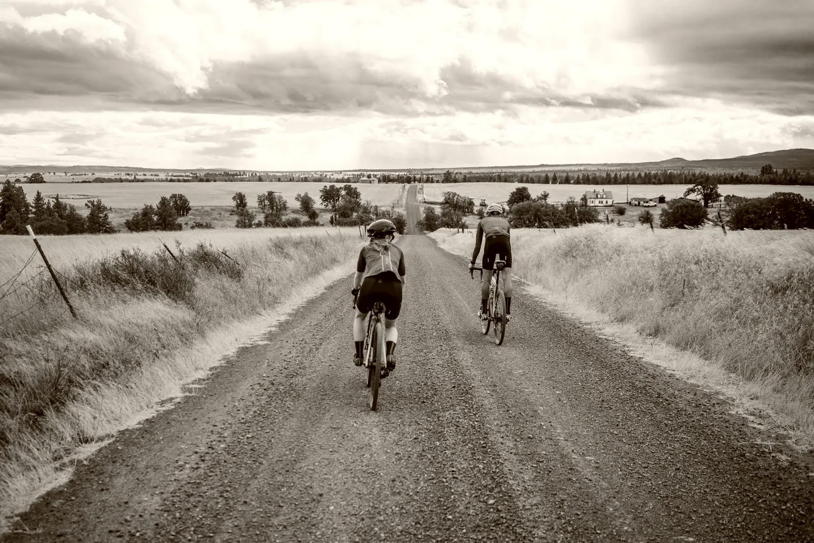 Two riders on the same gravel road, at different points